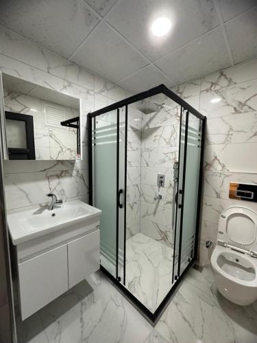 y baño con ducha, lavabo y aseo. en Antik Otel, en Kayacık