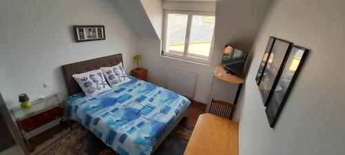 um pequeno quarto com uma cama e uma televisão em Ecrin de tranquillité - Centre Village em Barneville-Carteret