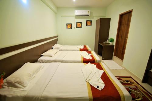 a hotel room with two beds and a bathroom at golden residency Mysore in Mysore