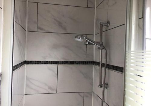 a bathroom with a shower with white tile at LPL Paris Hotel in Paris