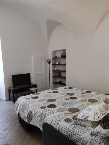 een slaapkamer met een bed, een stoel en een bureau bij Appartement quartier du vieux port de Bastia in Bastia