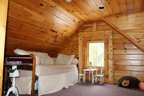 1 dormitorio con 1 cama en una cabaña de madera en Log Cabin on Saltwater Cove, en Ellsworth