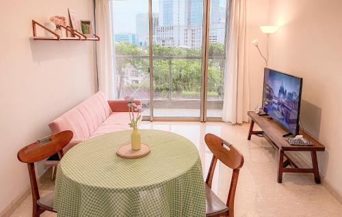 a living room with a table and a television at Gold Coast Apartment PIK Lovely Stay Near Airport in Jakarta