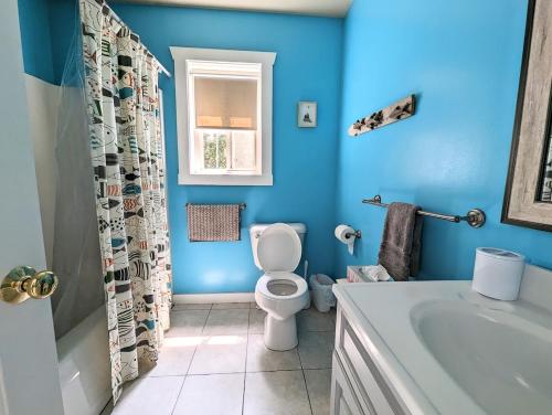 niebieska łazienka z toaletą i umywalką w obiekcie Sunset Cove Cottage private beach w mieście Prospect Harbor