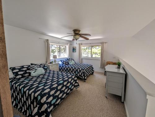 1 dormitorio con 2 camas y ventilador de techo en Sunset Cove Cottage private beach en Prospect Harbor