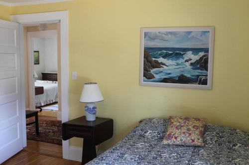 - une chambre avec un lit et une peinture murale dans l'établissement Ocean Breezes Fire Pit, à Ellsworth