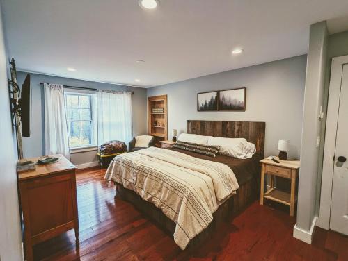 a bedroom with a large bed and a chair at Bar Harbor Hikers Dream in Bar Harbor