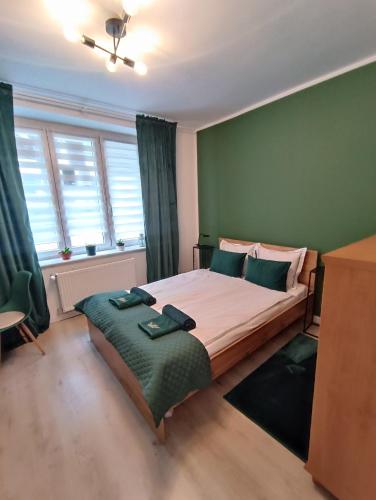 1 dormitorio con 1 cama grande y paredes verdes en Jackowskiego Zielony en Poznan
