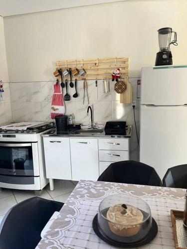 a kitchen with a table with a bowl of food on it at Sobrado 2 quartos - c/ piscina e churrasqueira in Rondonópolis