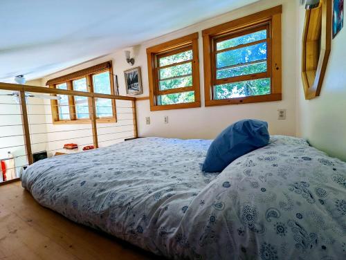 um quarto com uma cama num quarto com janelas em Tiny Trenton Beach House em Trenton