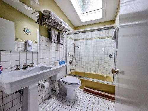 a bathroom with a sink and a toilet and a shower at Oceanfront Crackling Cove Cottage NEW in Prospect Harbor