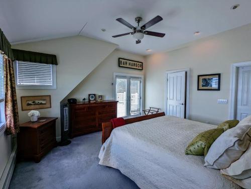 um quarto com uma cama e uma ventoinha de tecto em Oceanfront Jellison Beach House em Hancock