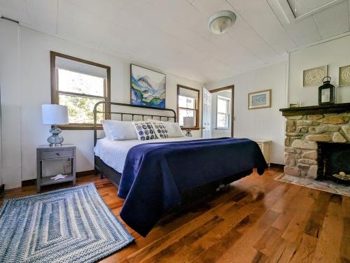 1 dormitorio con 1 cama y chimenea en Lone Pine Oceanfront Cottage, en Prospect Harbor