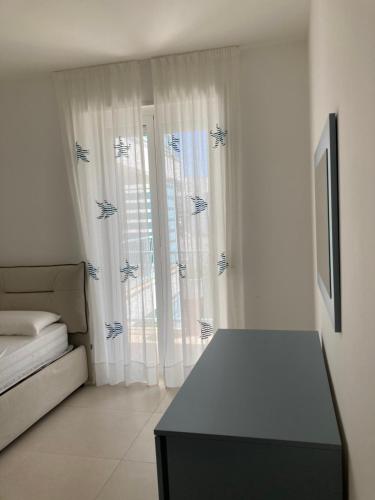 um quarto branco com uma cama e uma janela em La Fanciulla - Rooftop Apartment em Leuca