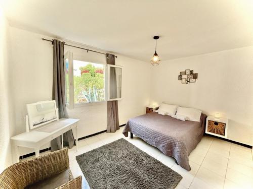 a bedroom with a bed and a desk and a window at Residence Canella in Sari Solenzara