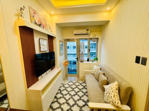 a living room with a couch and a television at SMDC Vine Residences Condo in Manila