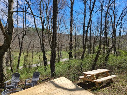 two chairs and a wooden picnic table in the woods at Black Oak Campsite at Hocking Vacations Campsites - Tent not Included in Logan