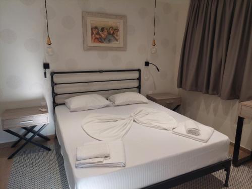 a bed with white sheets and towels on it at Villa Don Kostangelo in Nikiana