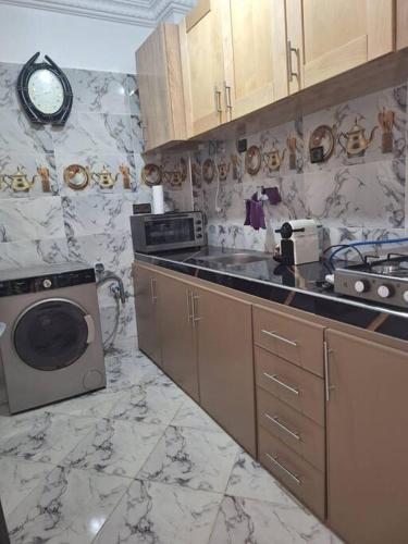 a kitchen with a sink and a washing machine at Votre chez-vous à Agadir in Agadir
