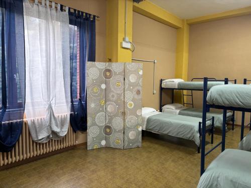 a hospital room with two bunk beds and a window at Ostello Bellavita in Castelnuovo di Garfagnana