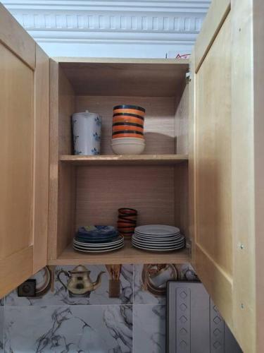 a cupboard with plates and bowls and dishes in it at Votre chez-vous à Agadir in Agadir