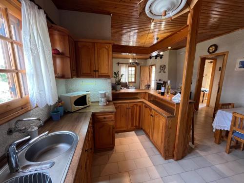 a kitchen with wooden cabinets and a sink at Rustic and Spacious House in Mytilinioí