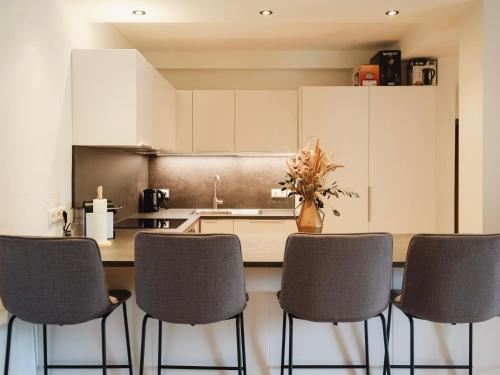 a kitchen with a counter with chairs and a table at Ehrenberg Apartments in Reutte