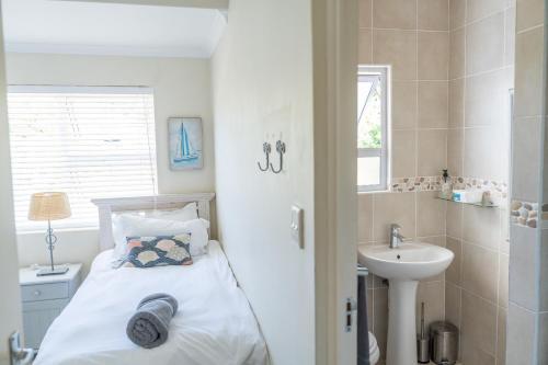a small bathroom with a bed and a sink at Villa 43, The Estuary Country Estate, Port Edward, KZN South Coast in Port Edward