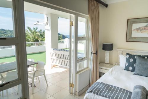 a bedroom with a bed and a balcony at Villa 43, The Estuary Country Estate, Port Edward, KZN South Coast in Port Edward