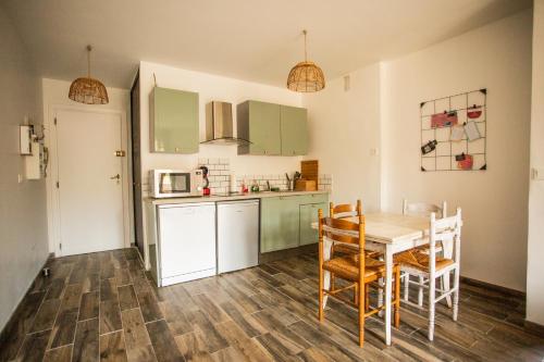 une cuisine avec une table et des chaises dans une pièce dans l'établissement T2 Cavalaire sur mer proche centre ville, à Cavalaire-sur-Mer