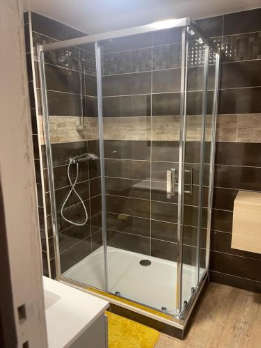 une douche avec une porte vitrée dans une salle de bain dans l'établissement Hotel du Centre, à Gueugnon