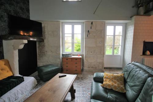 a living room with a couch and a table at Gîte La Vigne Verte in Saint-Sigismond
