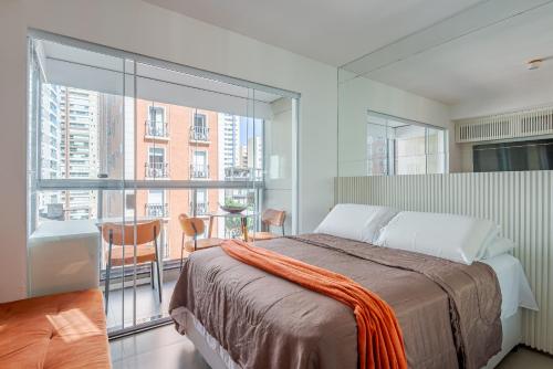 een slaapkamer met een bed en een groot raam bij Apartamento novo e completo próximo a paulista in Sao Paulo