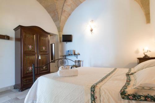 a bedroom with a bed and a tv on a wall at I SOGNI DI VENERE in Torre Suda