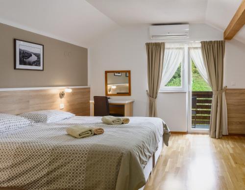 a bedroom with a bed with two towels on it at Tourist Center Marko in Oštarski Stanovi