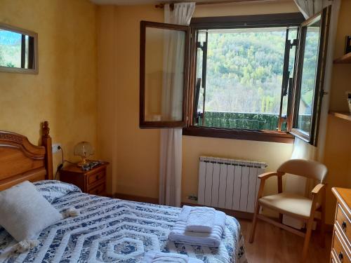 a bedroom with a bed and a window and a chair at Peña Telera in Panticosa