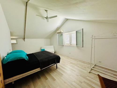 une chambre avec un lit et un ventilateur de plafond dans l'établissement Maison avec piscine, à Antibes