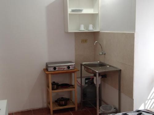 una pequeña cocina con fregadero y encimera en Aparthotel ANDESITA CUSCO, en Cusco