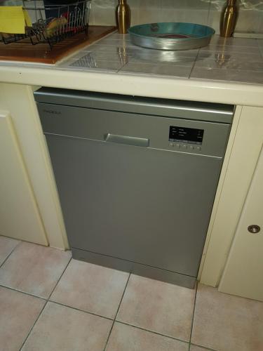 - un lave-vaisselle dans la cuisine sous un comptoir dans l'établissement Maison au calme, à Castillon-du-Gard