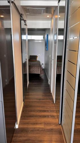 un couloir menant à une chambre avec un lit dans l'établissement Village naturiste, Port-Ambonne, appartement 42 m2, Le luxueux., au Cap d'Agde