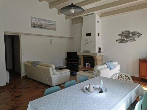 un salon avec une table et un canapé dans l'établissement Maison La Palmyre, aux Mathes