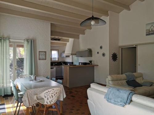 un salon avec un canapé blanc et une table dans l'établissement Maison La Palmyre, aux Mathes