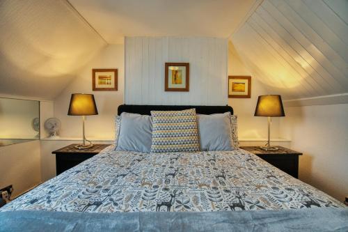 Un dormitorio con una cama grande con dos lámparas. en Pitfaranne Guest House, en Inverness