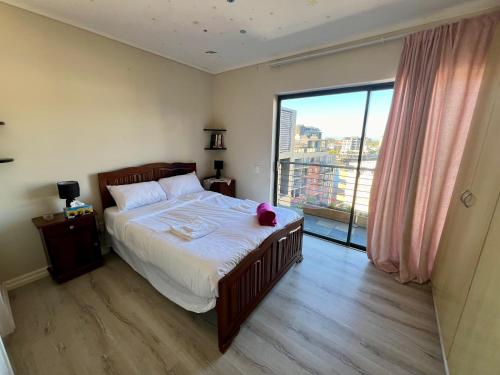 een slaapkamer met een bed met een teddybeer erop bij The Hippo in Kaapstad