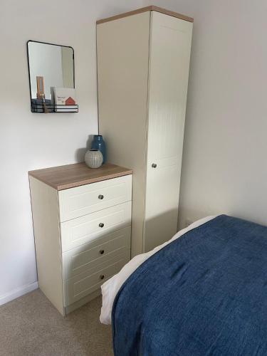 a bedroom with a bed and a dresser with a mirror at Cosy home close to M6 motorway in Pemberton