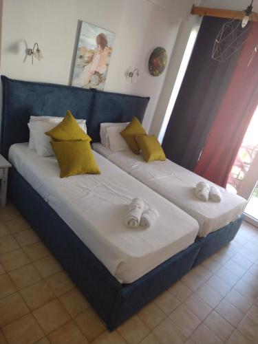 two beds in a room with yellow and white pillows at Art Studios Benitses in Benitses