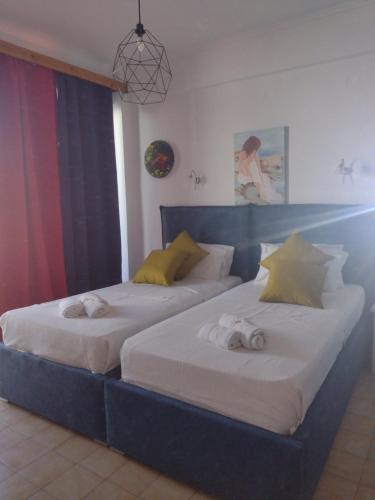 two beds in a room with two bedsitures at Art Studios Benitses in Benitses