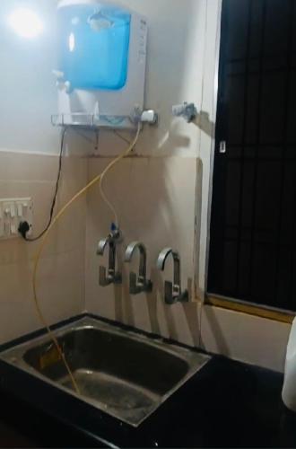 um lavatório de cozinha com duas torneiras na parede em Pretty park facing 2 bedroom guesthouse near lohia park Gomtinagar em Lucknow