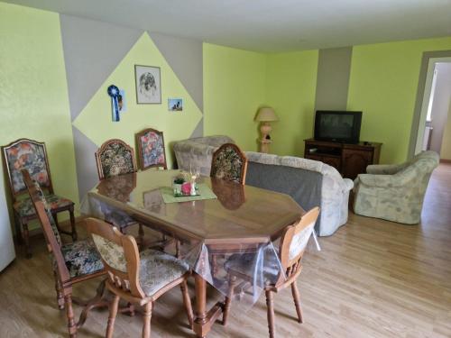 sala de estar con mesa de madera y sillas en Appartement dans Maison en pleine campagne, en Métairies-Saint-Quirin