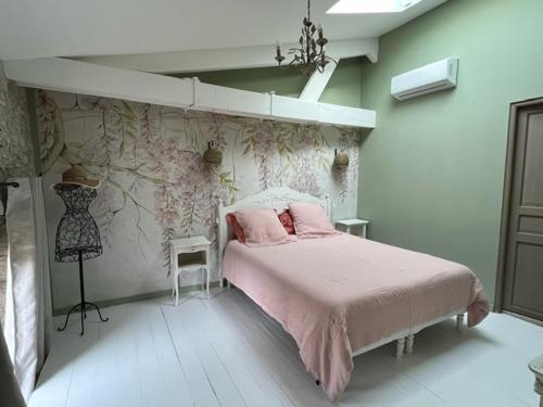 une chambre avec un lit avec une couverture rose dans l'établissement Le Mas du Pigeonnier, à Réauville